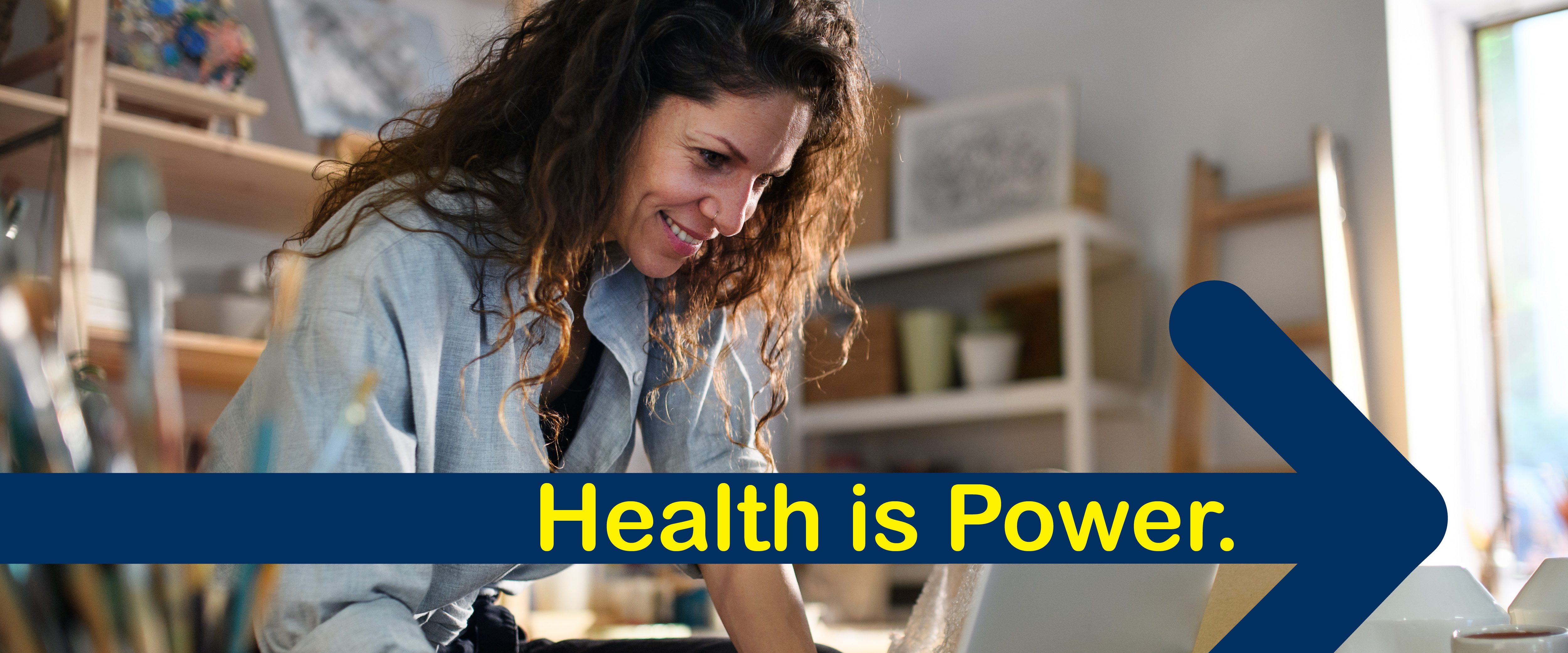Woman working in an art studio with a graphic of an arrow that reads "Health is Power".